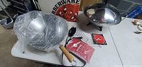 Unused Farberware electric wok with wooden handle, stainless steel skillet, original box, instruction booklet, red mitt, and power cord shown on table.