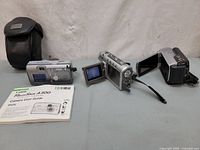 Overall view of Canon camera, Sony and Medion camcorders, case and manual