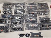 All 24 sealed pairs of Jianlong sunglasses laid out with pouches