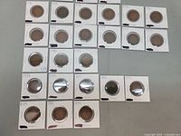 Overview of 27 Canadian one-cent coins in flips, showing arrangement and handwritten dates.