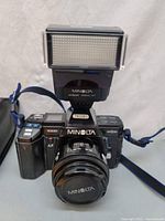 Front view of camera with flash mounted, showing model names