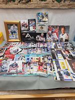 Overview of table with loose cards, sealed packs, boxed set, framed autograph, autographed card