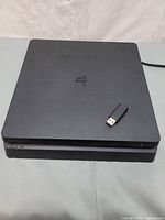 Top view of PlayStation 4 Slim console with USB dongle