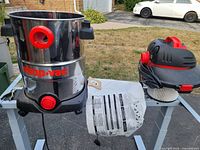 Complete vacuum disassembled showing stainless steel drum, motor head, hose port, drain plug, pleated filter, paper filter bag and manual