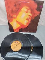 Front cover with orange close-up of Hendrix and both vinyl discs