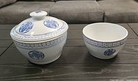 Lidded porcelain bowl and matching open bowl on table