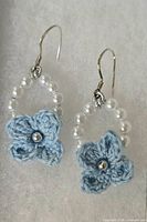 Front view of both earrings showing crocheted flowers, faux pearls and hooks