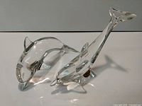 Two lead crystal dolphin figurines together