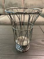 Full view of metal wire pedestal basket urn showing design, finish and condition