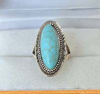 Front view of ring showing oval turquoise cabochon and beaded bezel
