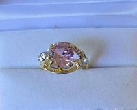 Front view of fashion ring showing pink centre stone and clear accents