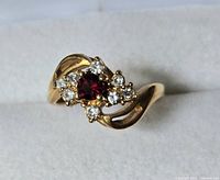 Ring frontal view showing red center stone and clear accents