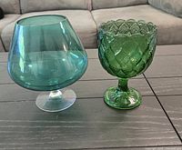 Both green glass pieces side by side on table