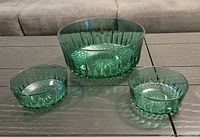 Three green Arcoroc glass bowls on table