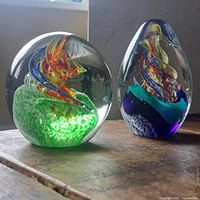 Both art glass paperweights showing shapes, colors, and condition