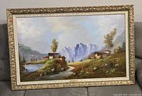 Framed landscape painting showing full view in ornate frame