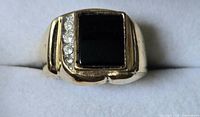 Top view of ring showing rectangular black stone and clear accent stones
