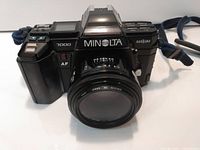 Front view of Minolta 7000 Maxxum with 50mm lens attached and strap visible