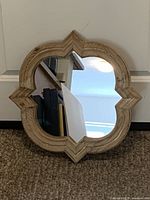 Front view of Moroccan quatrefoil mirror, showing wood frame and clear glass