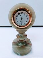 Front view of onyx pedestal desk clock showing dial and stone coloration