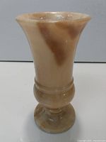 Full view of beige onyx vase with pedestal base and brown veining