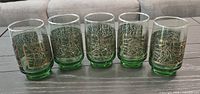 Five matching green Libbey David Douglas tumblers with gold design lined side by side on table