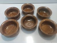 six wooden bowls displayed top view