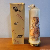 Candle on stand beside box