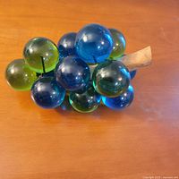 Full view of blue/green lucite grape cluster with wooden stem