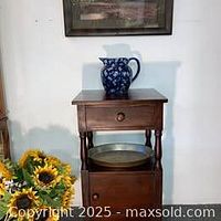 Side table with blue floral pitcher on top, showing finish and minor wear.
