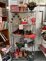 Full lot of assorted Christmas decorations on a metal shelving unit showing all items for sale