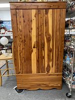 Full frontal view of the cedar wardrobe closet showing two doors and bottom panel with natural wood finish and wood grain.