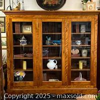 Front view of cabinet showing four glass-panel doors and interior adjustable shelves