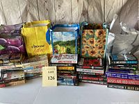 Photo showing stacks of books alongside four reusable bags with various designs and colors