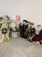 Full view of 6 Santa Claus figurines arranged in a row, showing different colors and accessories like wreaths, staffs, and garlands.