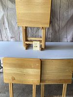 Six wooden folding TV trays, three shown front view with light natural wood finish and rounded edges.