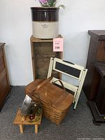 Photo showing the overall lot with picnic basket, wooden crate, folding stool, small birdhouse stool, and vintage iron visible