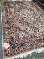 Full view of the entire rug laid out on the floor, showing overall pattern and fringed edges