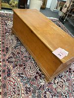 Angled full view of cedar chest on patterned rug showing overall exterior appearance