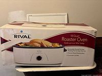 Original box of Rival 18 quart roaster oven showing product image and features on packaging