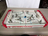 Full view of entire Pro-Stars Hockey tabletop game showing playing surface, players in positions, and nets on both ends.
