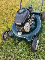 Front view of green Yardworks lawn mower showing black 4.5 HP engine block, front wheels and part of grass deck.