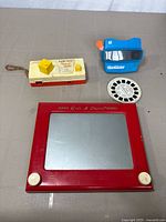 Overview of the three vintage items including Magic Etch A Sketch, Fisher Price Pocket Camera, and View-Master with a story disk