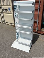 Front view of white retail shelving unit showing the 6 shelves with lips and branded background.