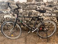 Full side profile of the black Minelli MT Diablo mountain bike showing the frame, wheels, and handlebars.