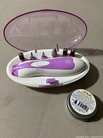 Open case showing electric nail trimmer and paw butter tin