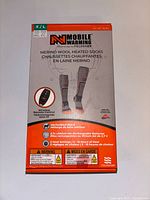 Front photo of product packaging showing Mobile Warming brand Merino Wool Heated Socks with wireless remote control and features.