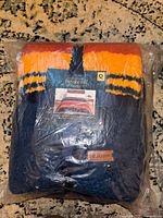New Pendleton queen blanket in original sealed plastic bag, label visible with color pattern dark blue, orange, and red stripes.