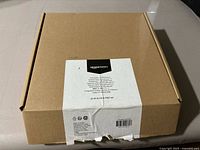 Closed cardboard box of Amazon Basics TV wall mount with label details on side