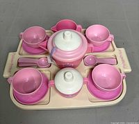 Top side view of complete tea set arranged on tray showcasing cups, spoons, teapot, creamer, and tray with Fisher Price branding.